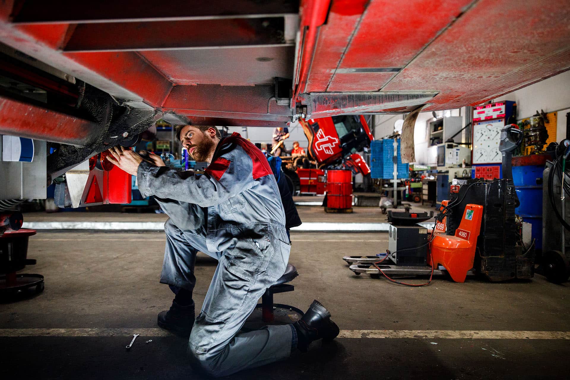 garagemedewerker aan het werk onder vrachtwagen