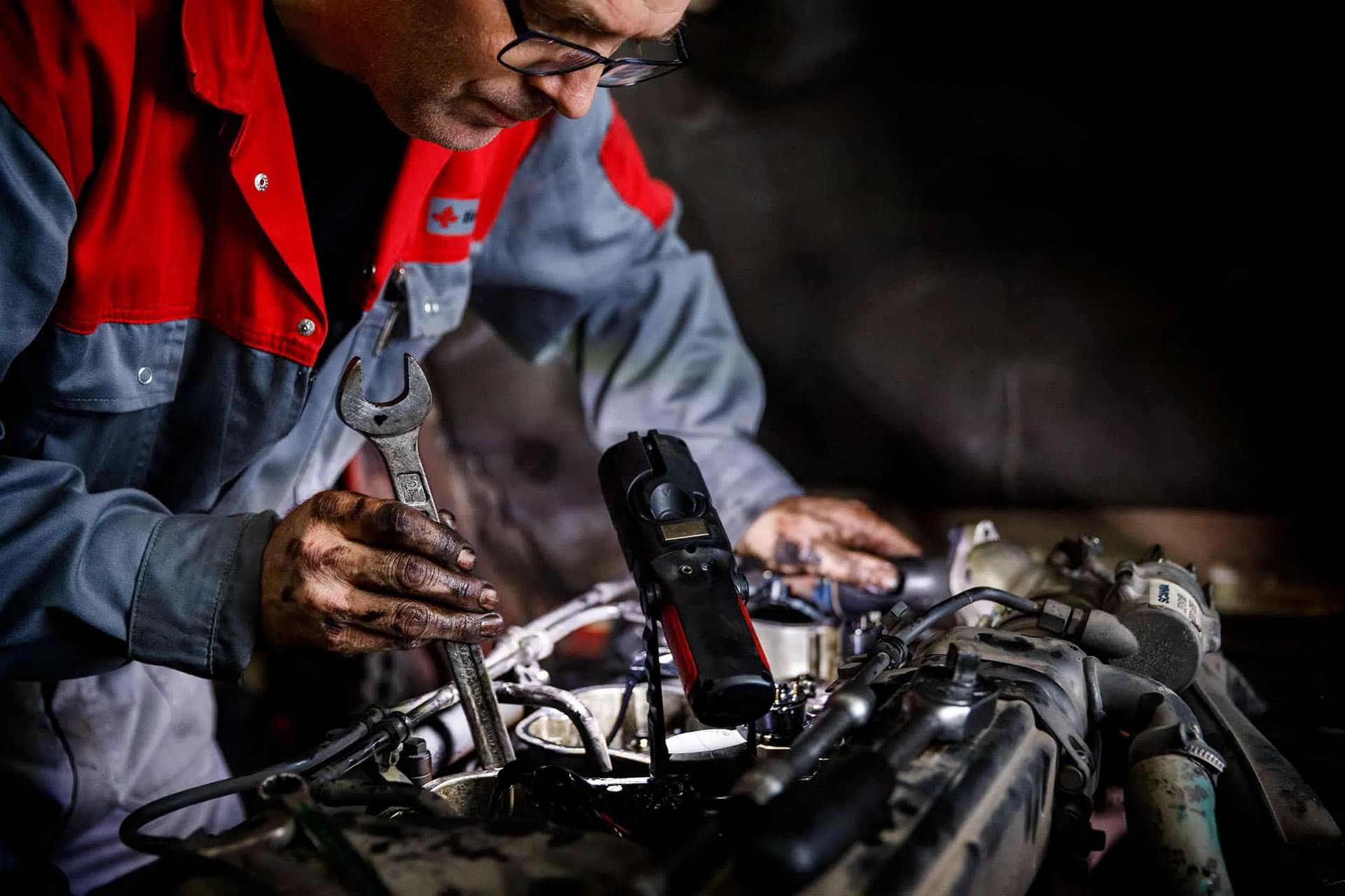 Garagemedewerker met zwarte handen van de olie bezig met reparatie of onderhoud vrachtwagen