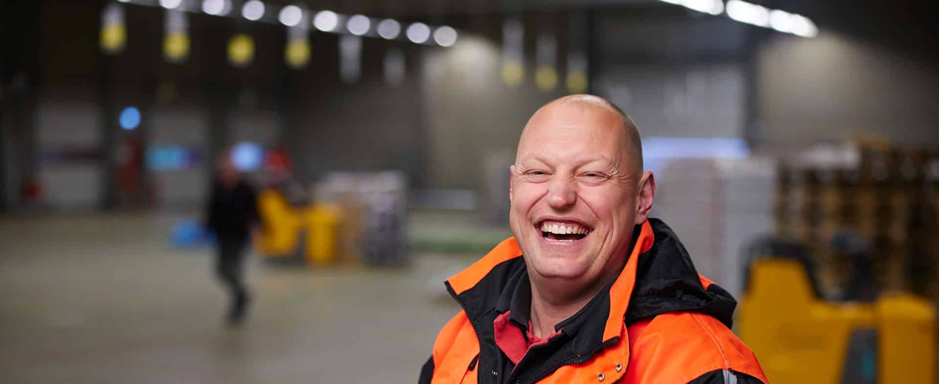 Chauffeur Erik met een grote lach in de loods