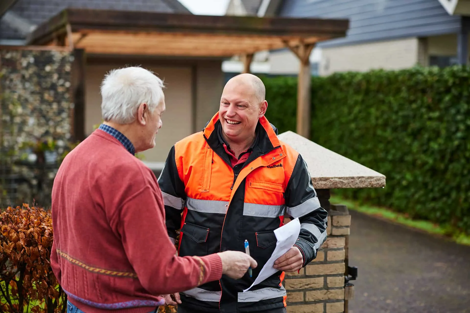 Lachende chauffeur in gesprek met klant