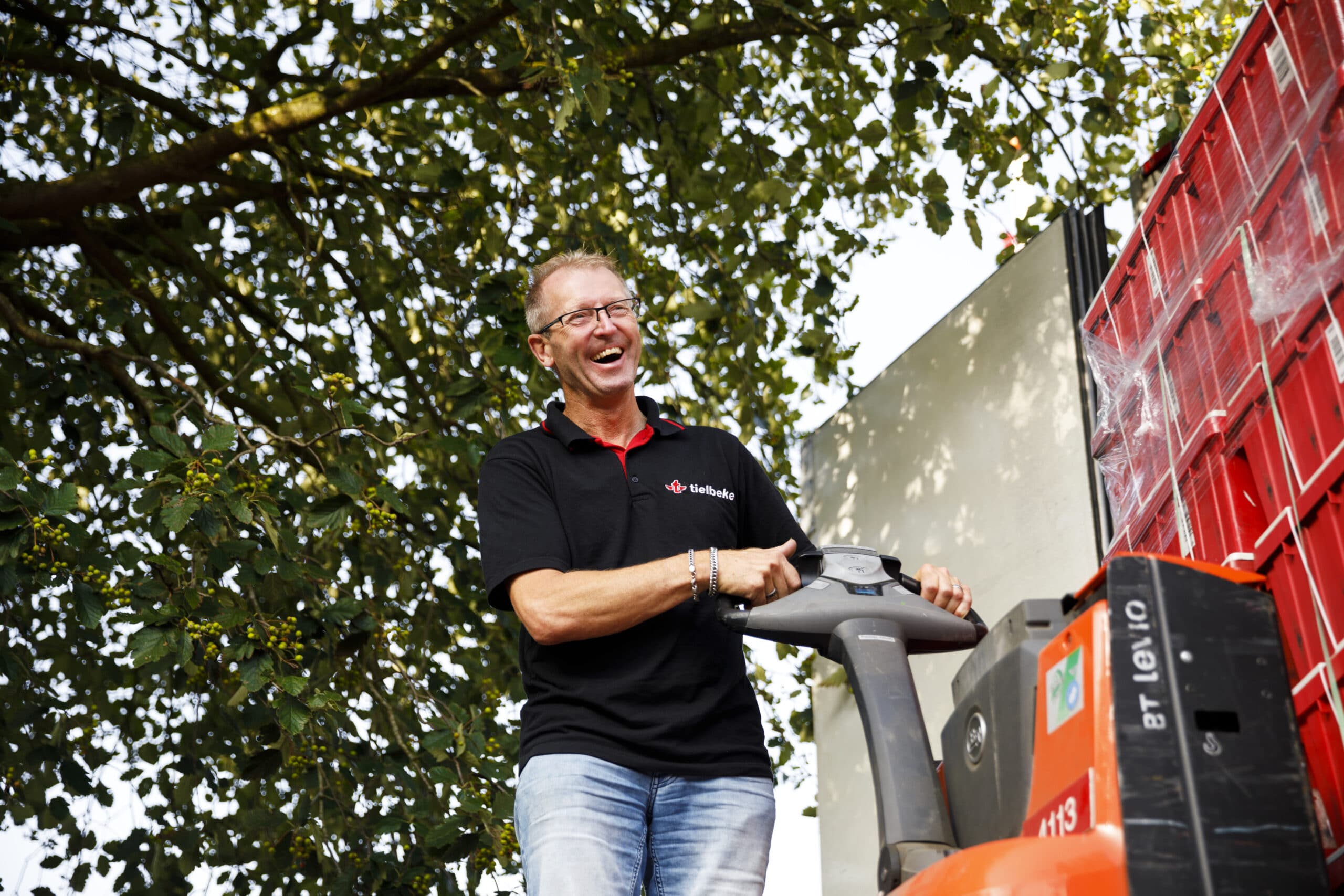 lachende chauffeur Marcel bezig met lossen