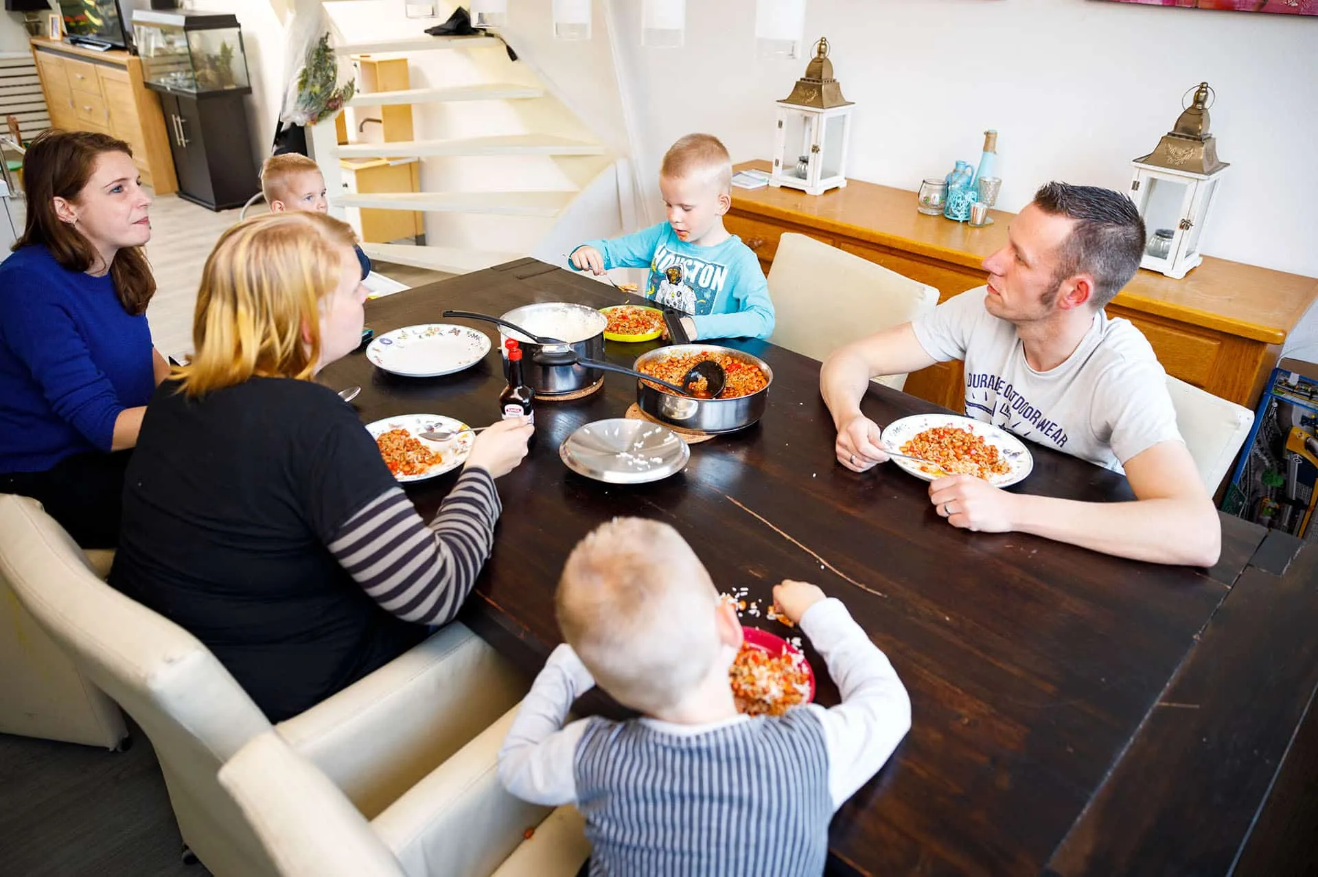 Gezin met vier kinderen eten aan tafel
