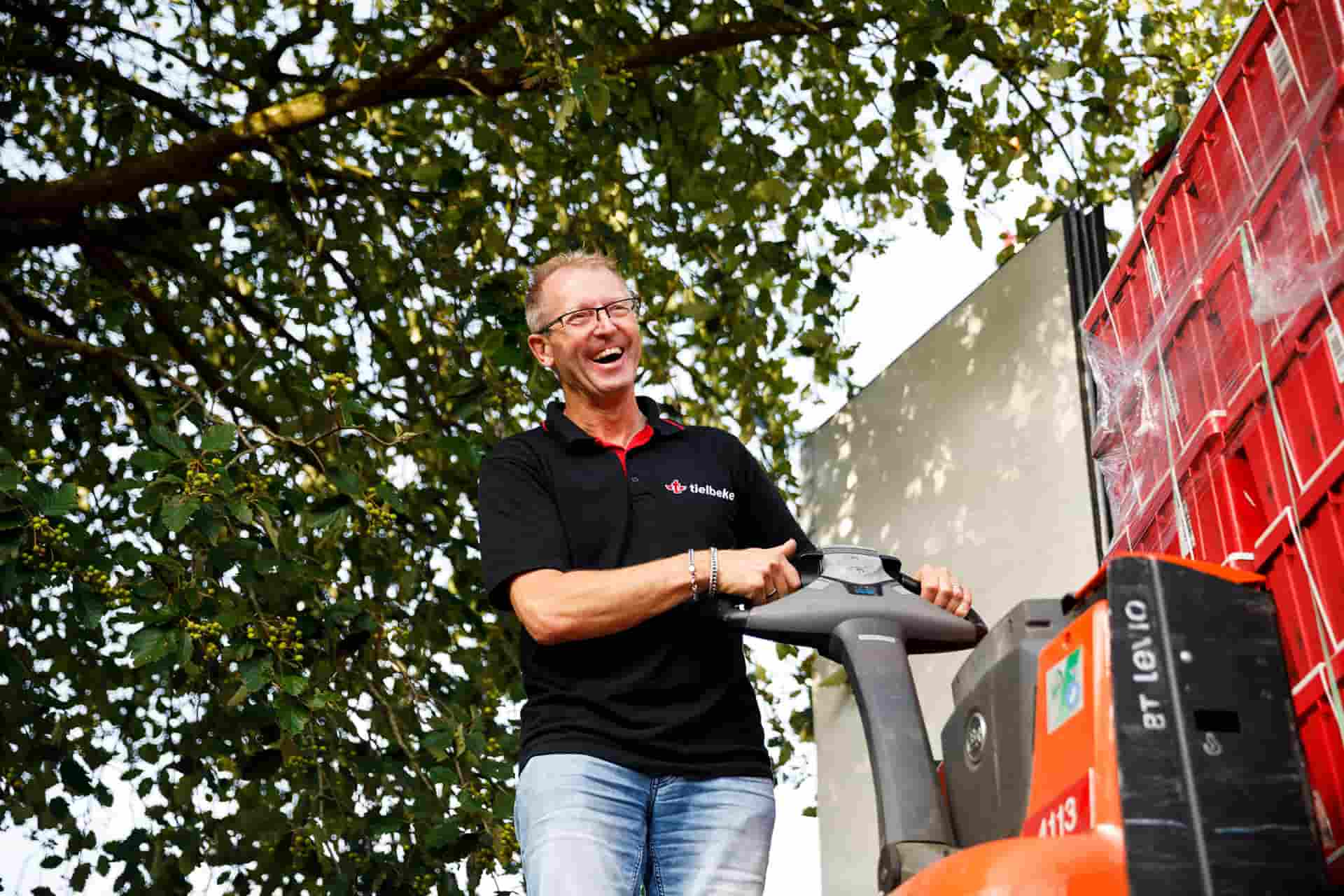 lachende chauffeur aan het laden en lossen