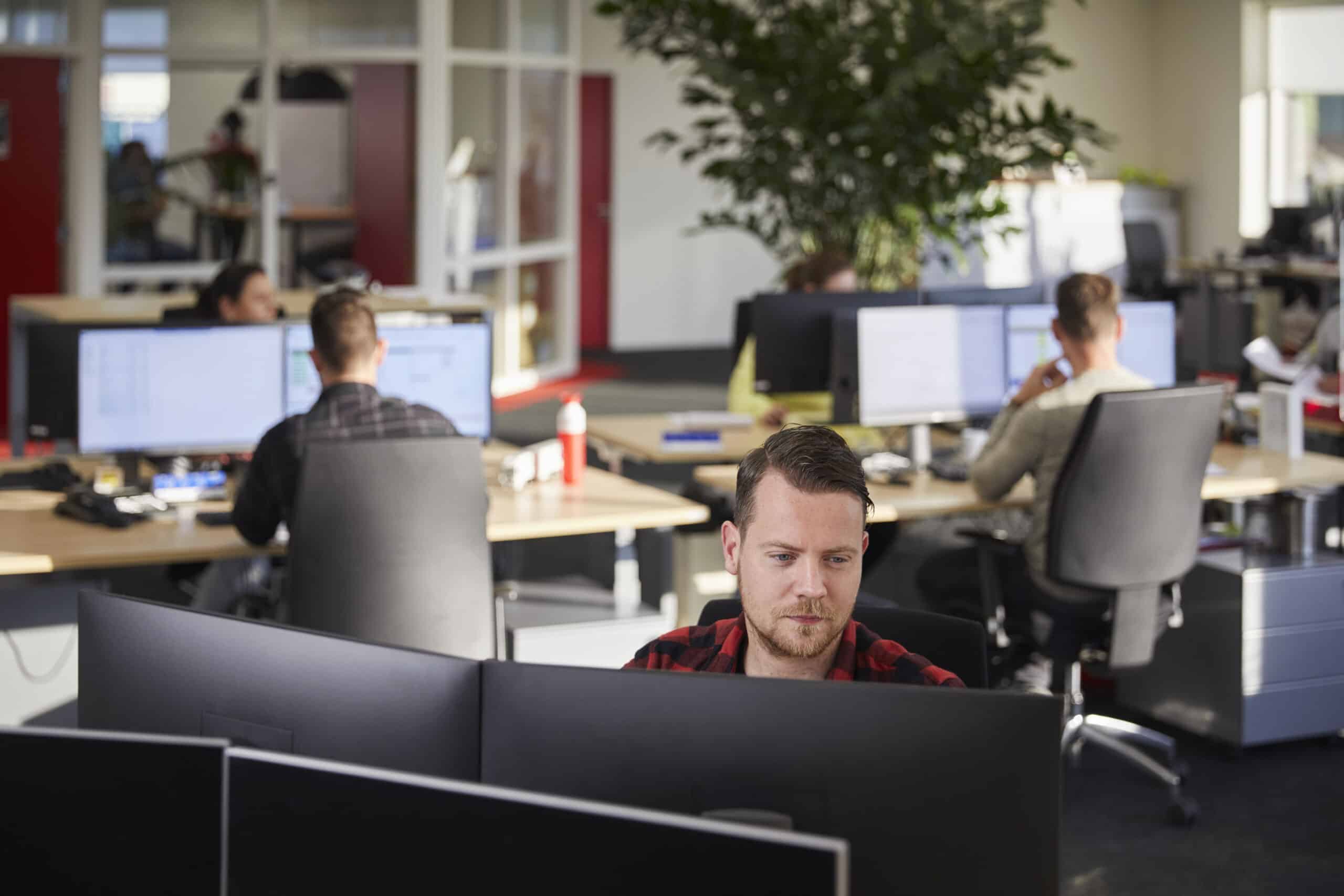 man werkt achter computer op kantoor