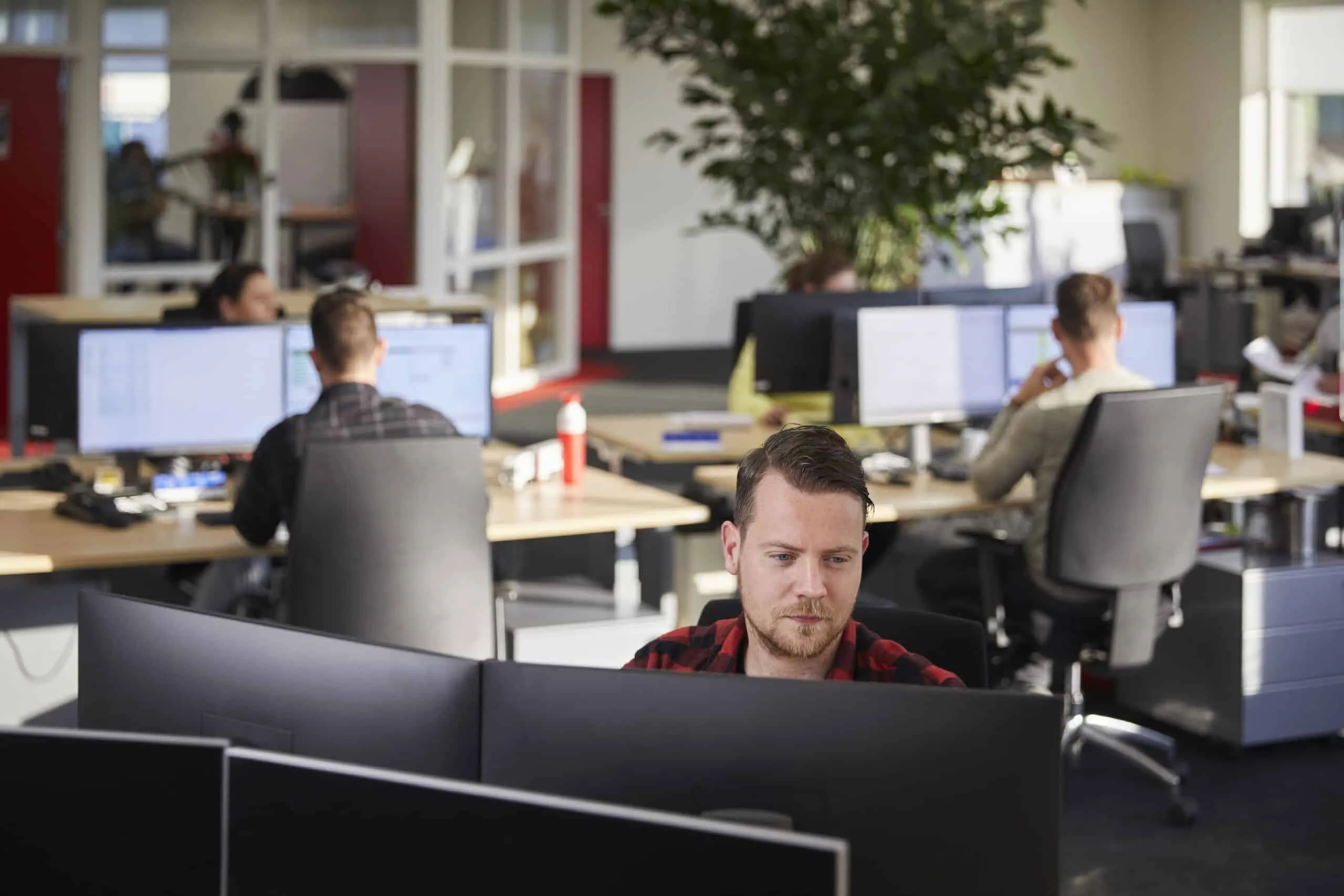 man werkt achter computer op kantoor