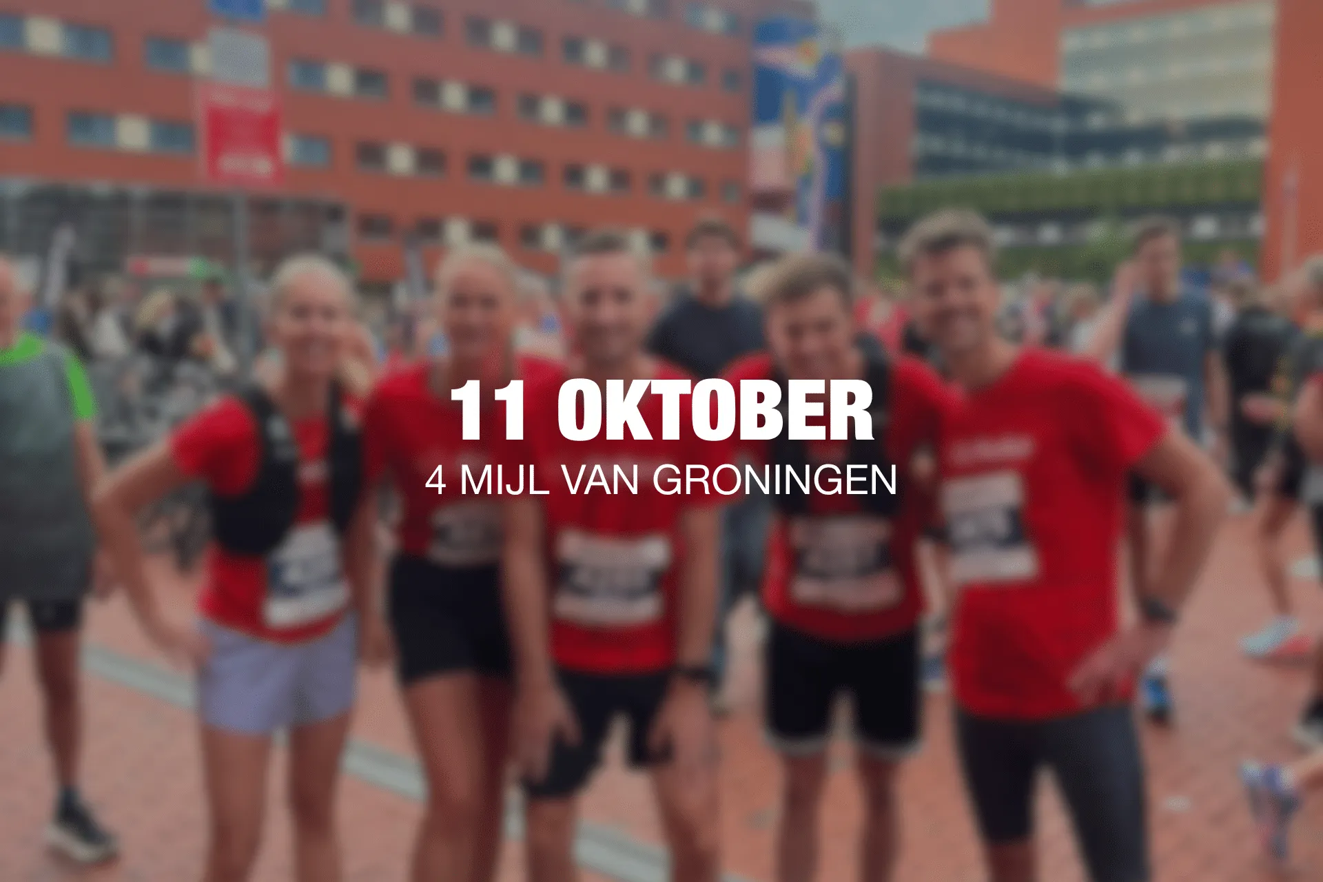Groep lopers in rode shirts poseren tijdens hardloopevenement in Groningen; overlaytekst: 11 OKTOBER, 4 MIJL VAN GRONINGEN.